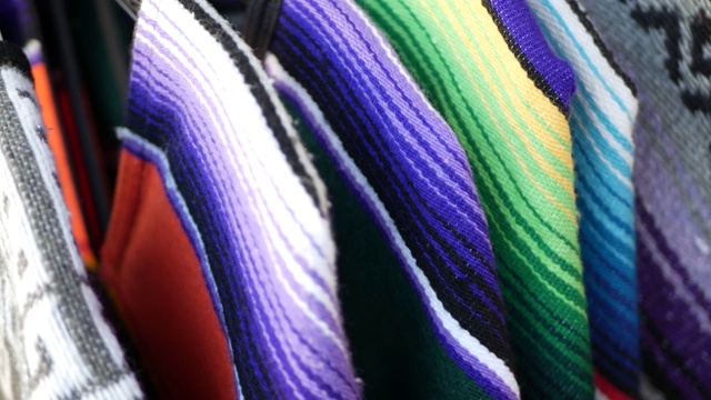 五颜六色的墨西哥羊毛毛毯的质地。编织装饰生动的纺织品与正宗的拉丁美洲图案。用于斗篷和宽边帽的条纹多色织物。西班牙本土风格视频下载