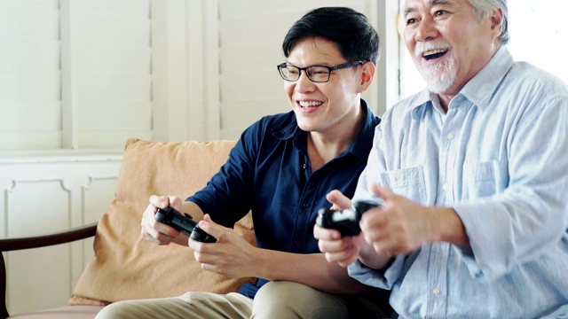 老父亲和他已成年的儿子喜欢一起玩电子游戏。视频下载