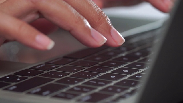一个女人在笔记本电脑键盘上打字视频下载