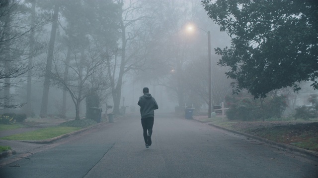 一个截肢的运动员在一个清晨沿着住宅道路自信地奔跑视频素材