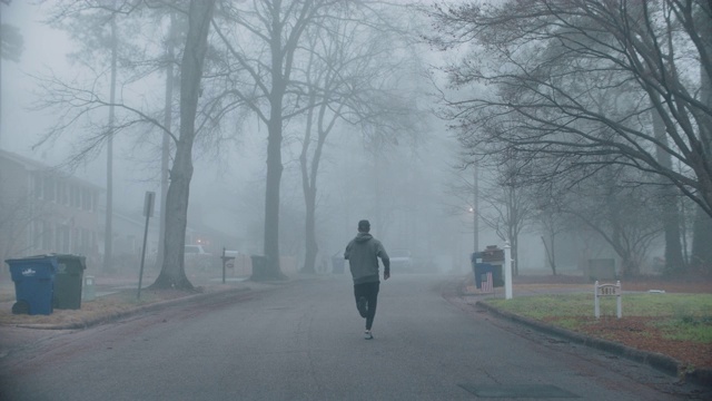 SLO MO适应性运动员在黎明沿着住宅道路跑步视频素材