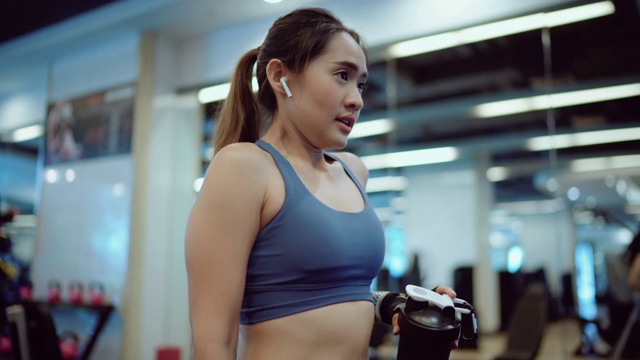 在健身房喝高蛋白奶昔的女运动员视频素材