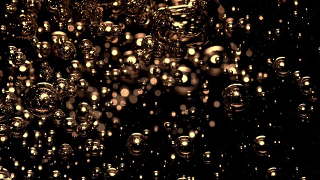 慢镜头和超微距镜头的倒水，使金色的小气泡水下在一个黑色的背景视频素材