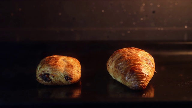 迷你巧克力面包和羊角面包在烤箱自制延时拍摄4K深色背景视频素材