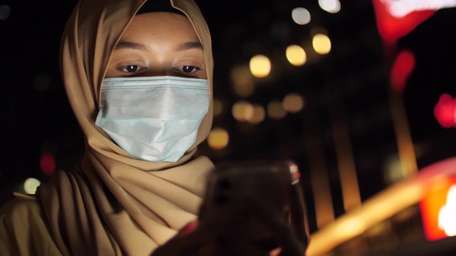 描绘穆斯林妇女在晚上使用智能手机的情景视频下载