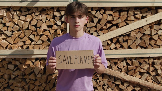 户外男子活动家与拯救地球的生态海报。在被砍倒的树木中视频下载