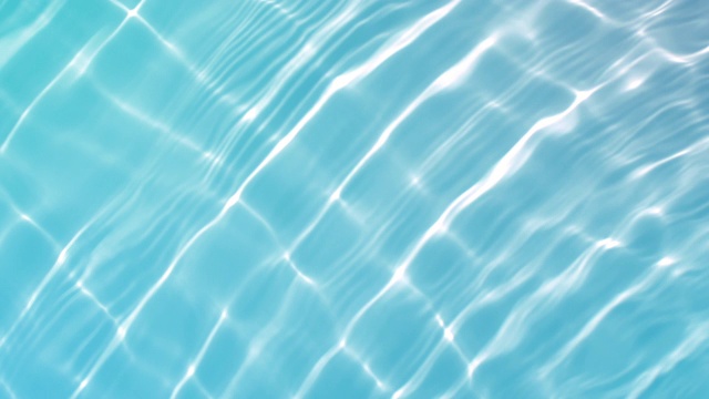 慢动作和头顶上的水反射在浅蓝色游泳池表面从一个直接的阳光视频素材