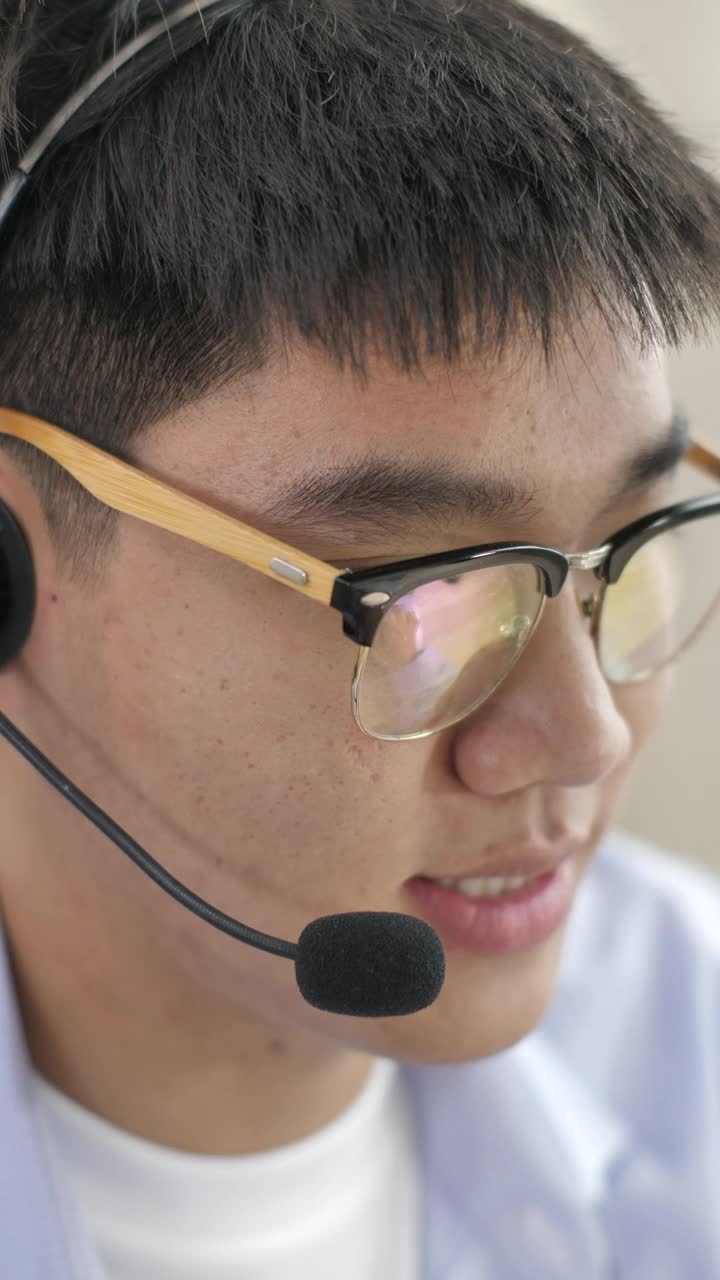 年轻的亚洲人在呼叫中心工作，垂直视图视频素材