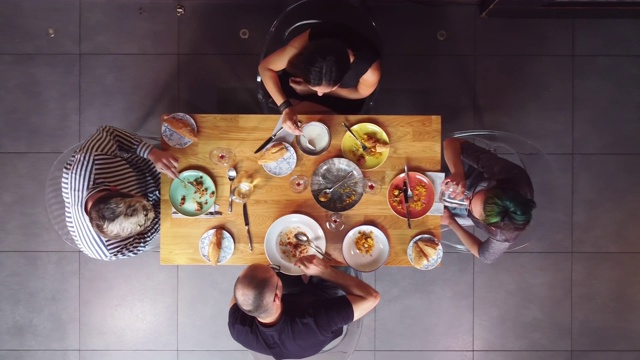 俯瞰一群朋友在餐厅享用晚餐。视频素材