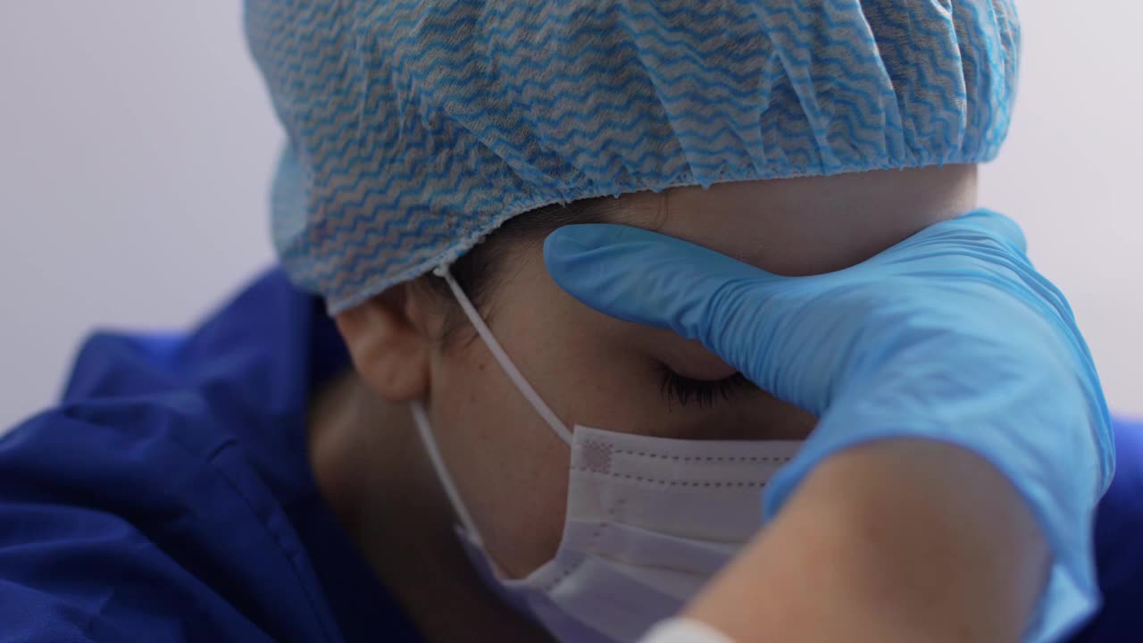 疲倦的医生或护士戴着口罩、手套和帽子视频下载