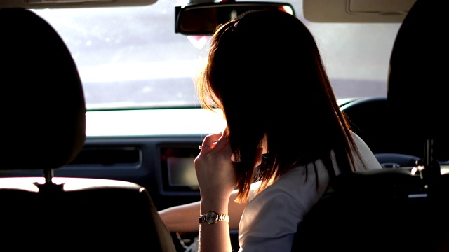 后视图女性司机使用手机在方向盘后面视频素材