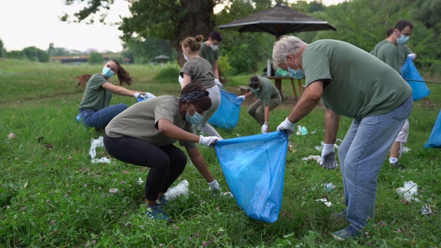 多民族志愿者在新冠肺炎大流行期间清扫公园视频下载