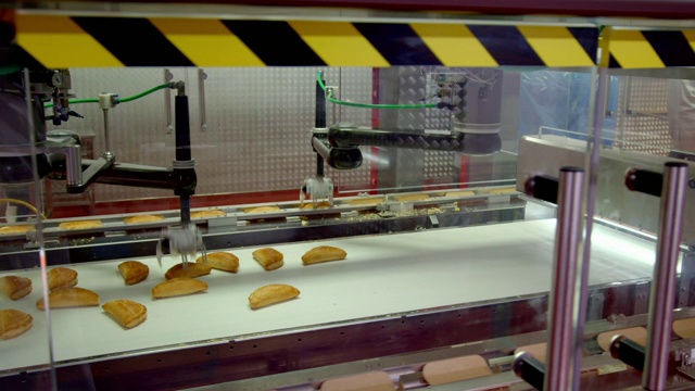 机器手臂将馅饼移到纸包装上视频素材