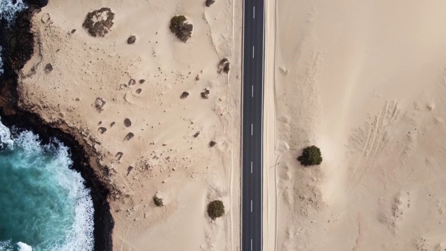 西班牙富埃特文图拉科拉雷霍沙丘之间的一条黑色道路的鸟瞰图视频下载