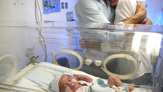 在新生儿重症监护室，快乐的拉丁美洲父母看着他们漂亮的婴儿视频素材