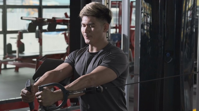 运动员在健身馆用机器健身锻炼肌肉和胸部，健康的生活方式耐力重负荷训练，积极健康的健美理念。视频下载