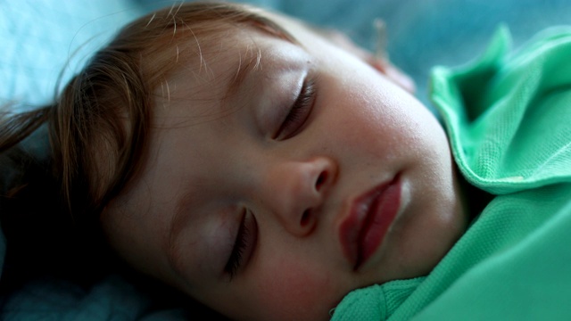 熟睡的婴儿，安静的蹒跚学步的孩子在床上打盹，特写的婴儿男孩的脸睡着了视频下载