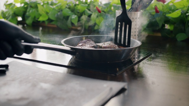 近距离观看煎锅与肉块和男性的手煮饭视频素材