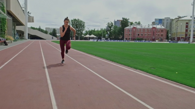 在跑道上跑步的女运动员。在田径跑道上慢跑的女运动员视频下载