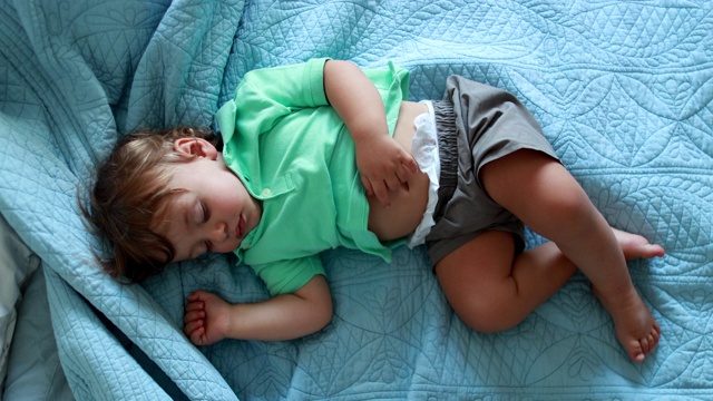 小男孩在床上打盹。可爱的婴儿在睡觉视频素材