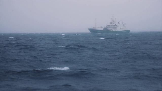 渔船在薄雾中捕鱼:冬天波涛汹涌的海面视频素材