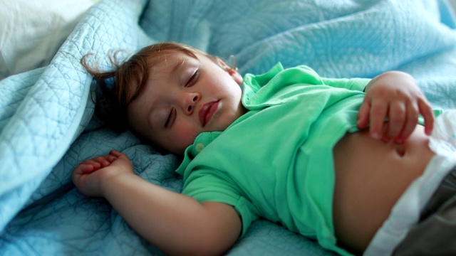 婴儿睡在床上午睡。安静的小男孩睡着了视频下载