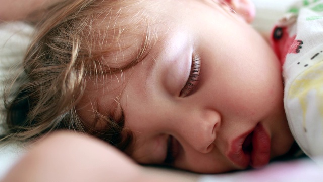 特写的宝宝睡觉。一岁的小男孩睡着了。特写镜头婴儿小睡视频下载