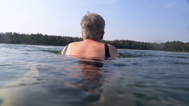 老年妇女在湖里游泳视频素材
