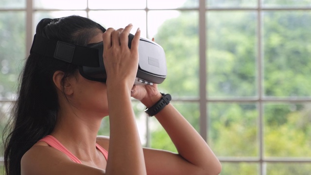 亚洲女性穿戴虚拟现实准备在家训练运动。可穿戴技术生活方式视频素材