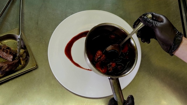 厨师将草莓酱和红酒酱倒在盘子上的特写。服务。视频素材