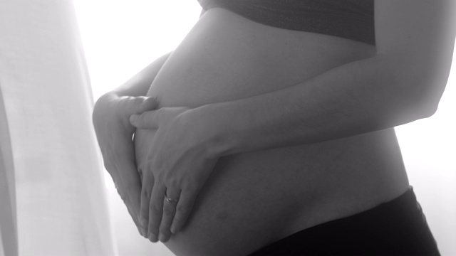 女人抱着怀孕的肚子。黑白艺术视频素材