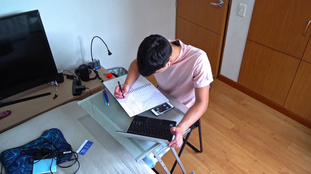 由于COVID-19大流行，年轻人在家做功课视频素材
