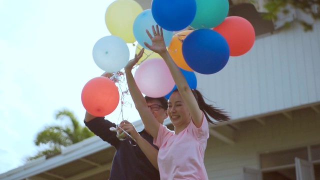无忧无虑的夫妇在花园房子玩气球，慢动作。视频素材