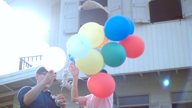 无忧无虑的夫妇在花园房子玩气球，慢动作。视频素材