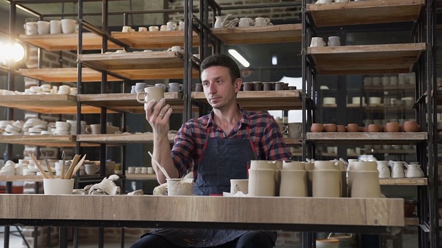 男陶工看手工帽子在工作日的陶器视频素材