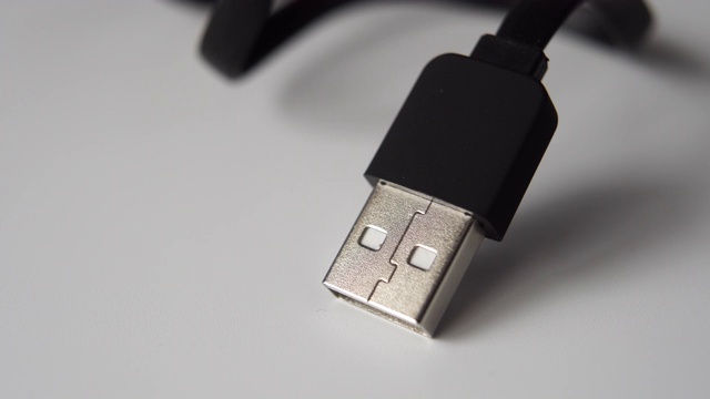 Usb插头与黑色电缆特写在一个灰色的表面。视频下载