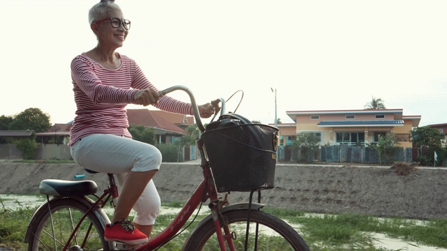 微笑的亚洲资深妇女与老式自行车视频素材
