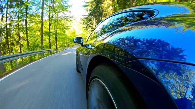 在一个美丽的阳光明媚的日子里，轻松的风景车在空旷的蜿蜒道路上行驶视频素材