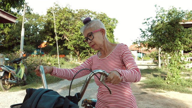 微笑的亚洲资深妇女与老式自行车视频素材
