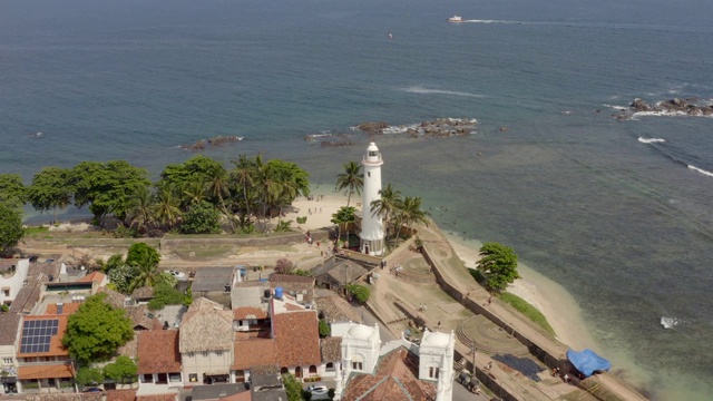 无人机拍摄的斯里兰卡加勒镇和灯塔。加勒是一个封闭在该国南部海岸堡垒墙中的殖民城镇。鸟瞰图公路角度视频素材