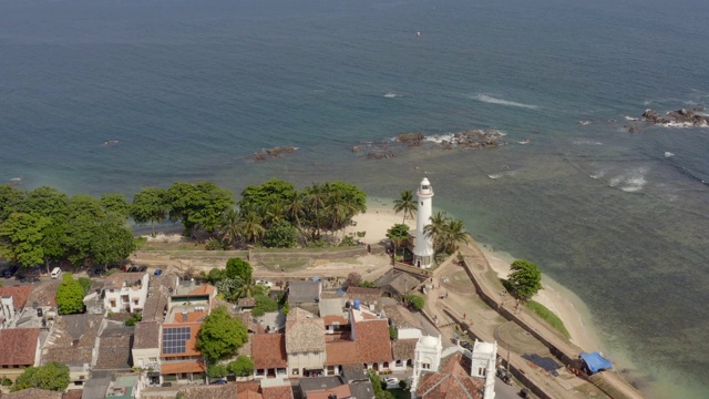 无人机拍摄的斯里兰卡加勒镇和灯塔。加勒是一个封闭在该国南部海岸堡垒墙中的殖民城镇。鸟瞰图公路角度视频素材