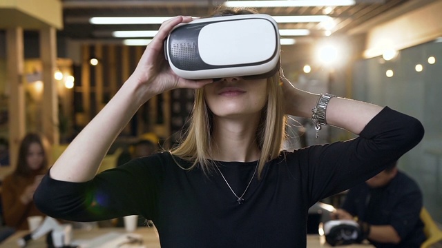 英俊的年轻女子戴着虚拟现实vr眼镜在办公室的背景视频素材