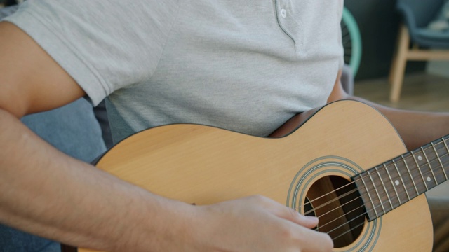 倾斜肖像英俊的阿拉伯男子吉他手弹奏吉他在家视频素材