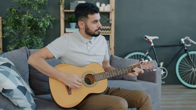 富有创造力的中东人在家里弹吉他享受乐器视频素材