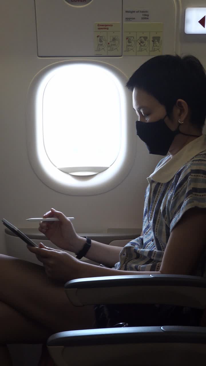 女人在飞机上戴着面具视频素材