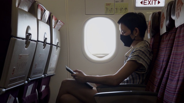 女人在飞机上戴着面具视频素材