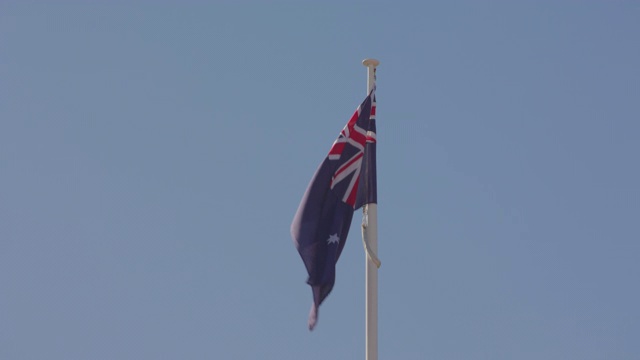 在澳大利亚悉尼，澳大利亚国旗骄傲地在风中飘扬，背景是清澈的蓝天视频素材
