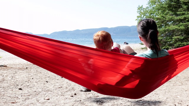 可爱的红发孩子有乐趣在红色吊床露营在夏天视频下载