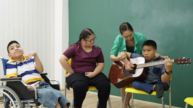 老师在教室里教残疾儿童吉他，非常开心视频素材
