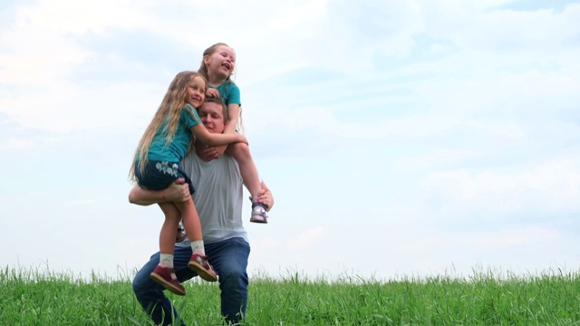 4 k。快乐的爸爸和两个小女儿一起笑着度过时光。爸爸和女儿在夏天一起玩。爸爸怀里抱着两个女孩视频素材